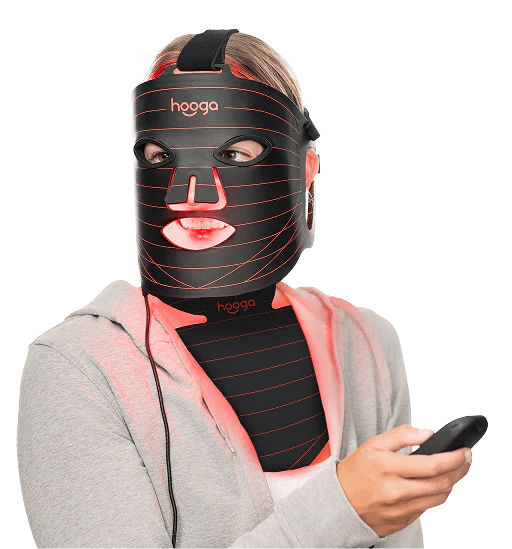 Woman using Hooga Red Light Face Mask with wireless remote control for LED therapy session