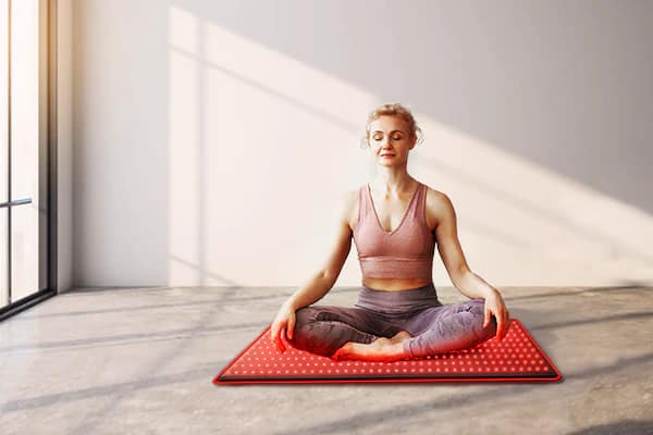 Woman meditating on BestQool LED Mat for combined mindfulness and red light therapy practice