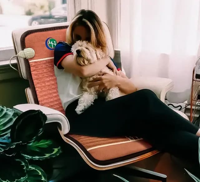 Young woman and dog resting on lounge chair with HealthyLine TAO PEMF Chair Mat for cozy relaxation