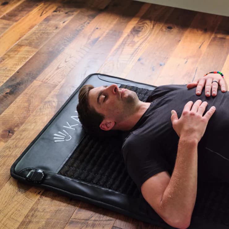 Man using Kala PEMF Mat for full-body TENS and PEMF therapy session