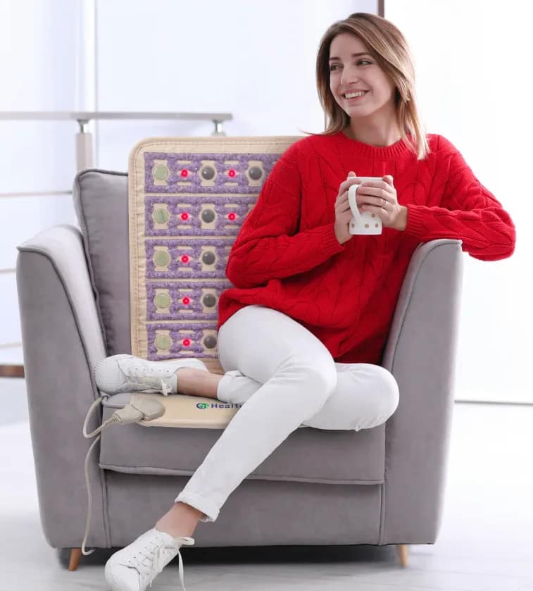 Woman enjoying coffee while using HealthyLine TAJ Chair PEMF Mat for back pain relief