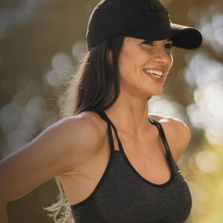 Woman enjoying outdoor activities while using Kala Red Light Hat for portable hands-free LED treatment
