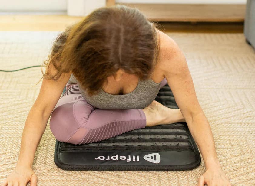 Female Using PEMF MiniMat In Yoga Pose For Wellness