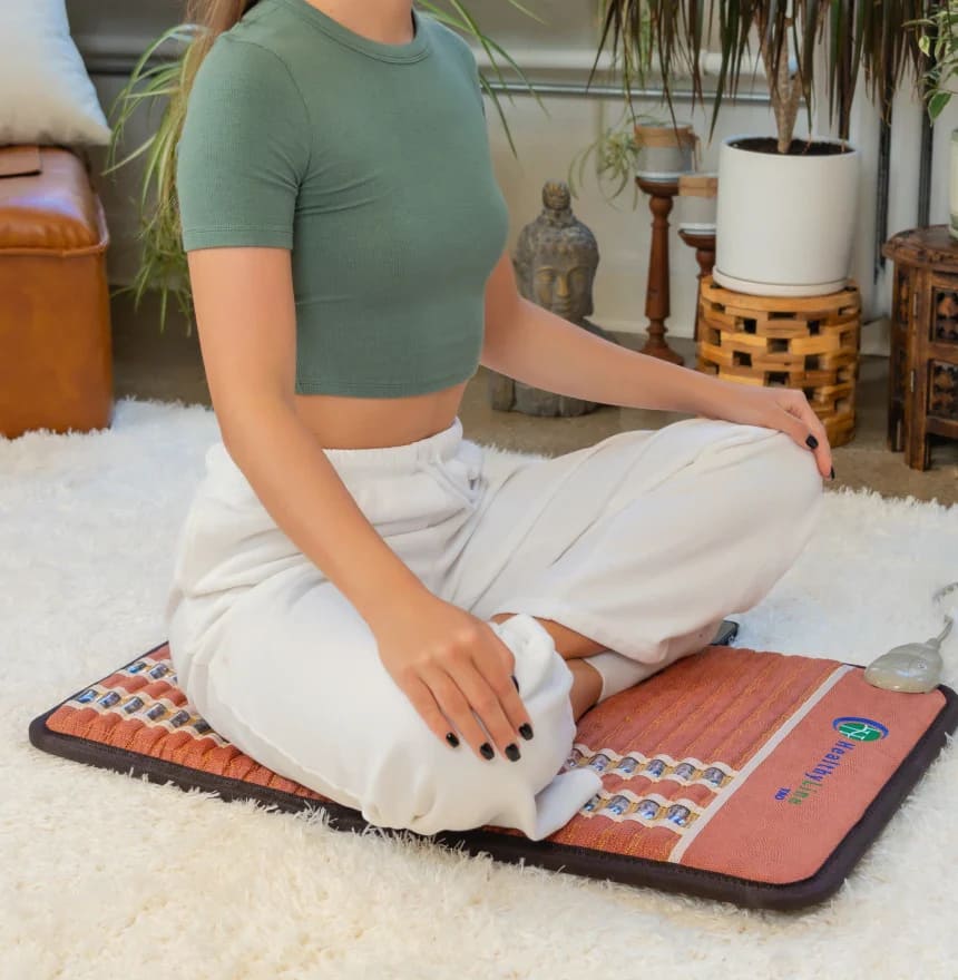 Woman relaxing and meditating on the HealthyLine TAO PEMF MiniMat for stress relief