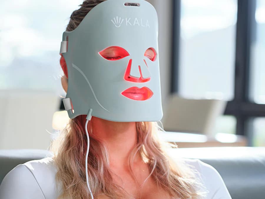 Woman using Kala LED Face Mask during home light therapy treatment session