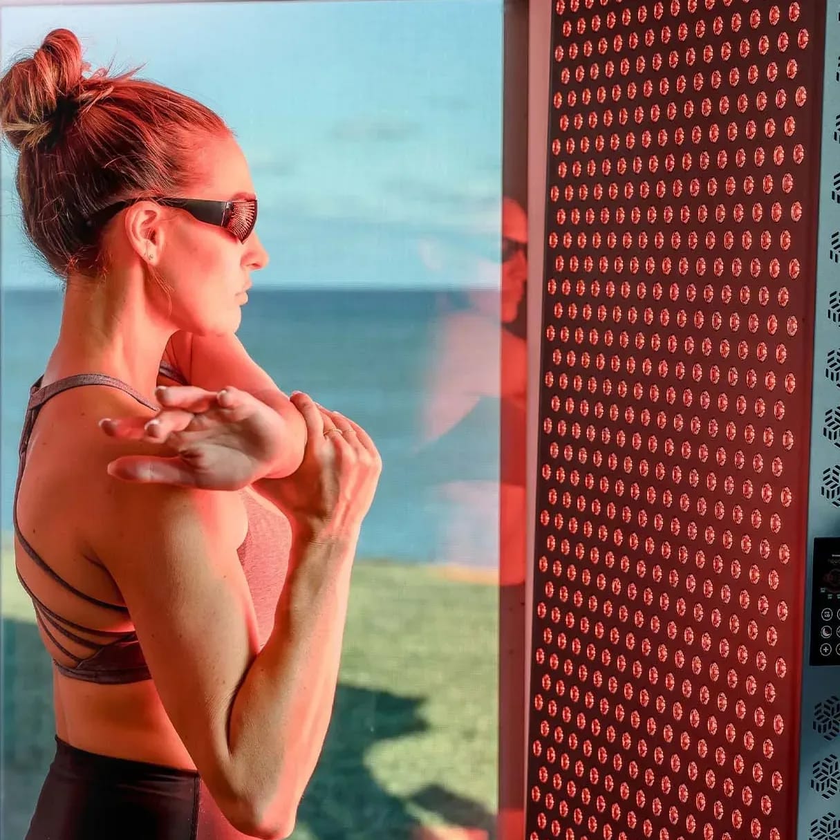 Woman with eye protection glasses in front of Hooga 4500 Red Light Panel