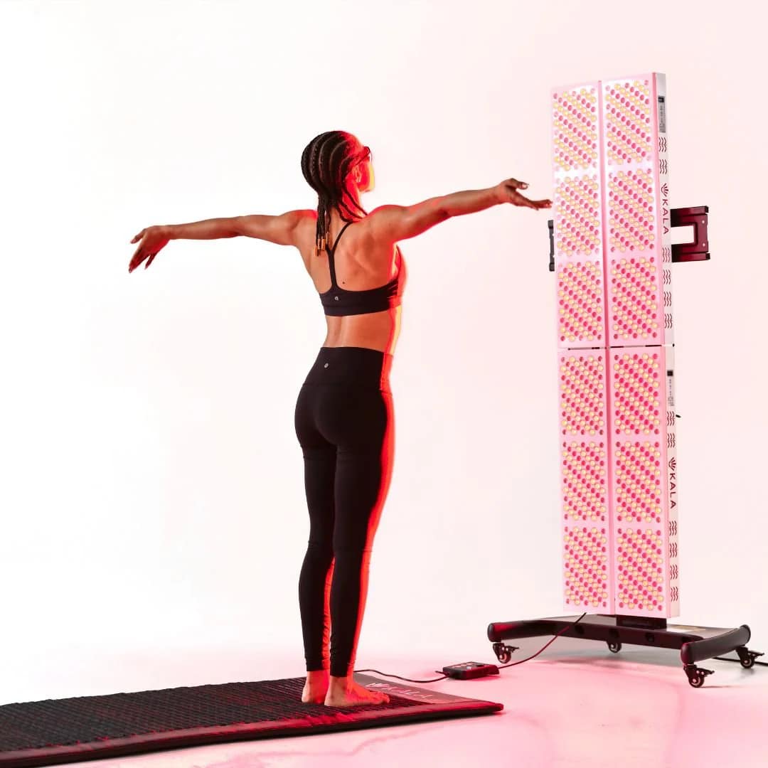 Woman practicing yoga during Kala Elite QUAD Red Light Therapy session