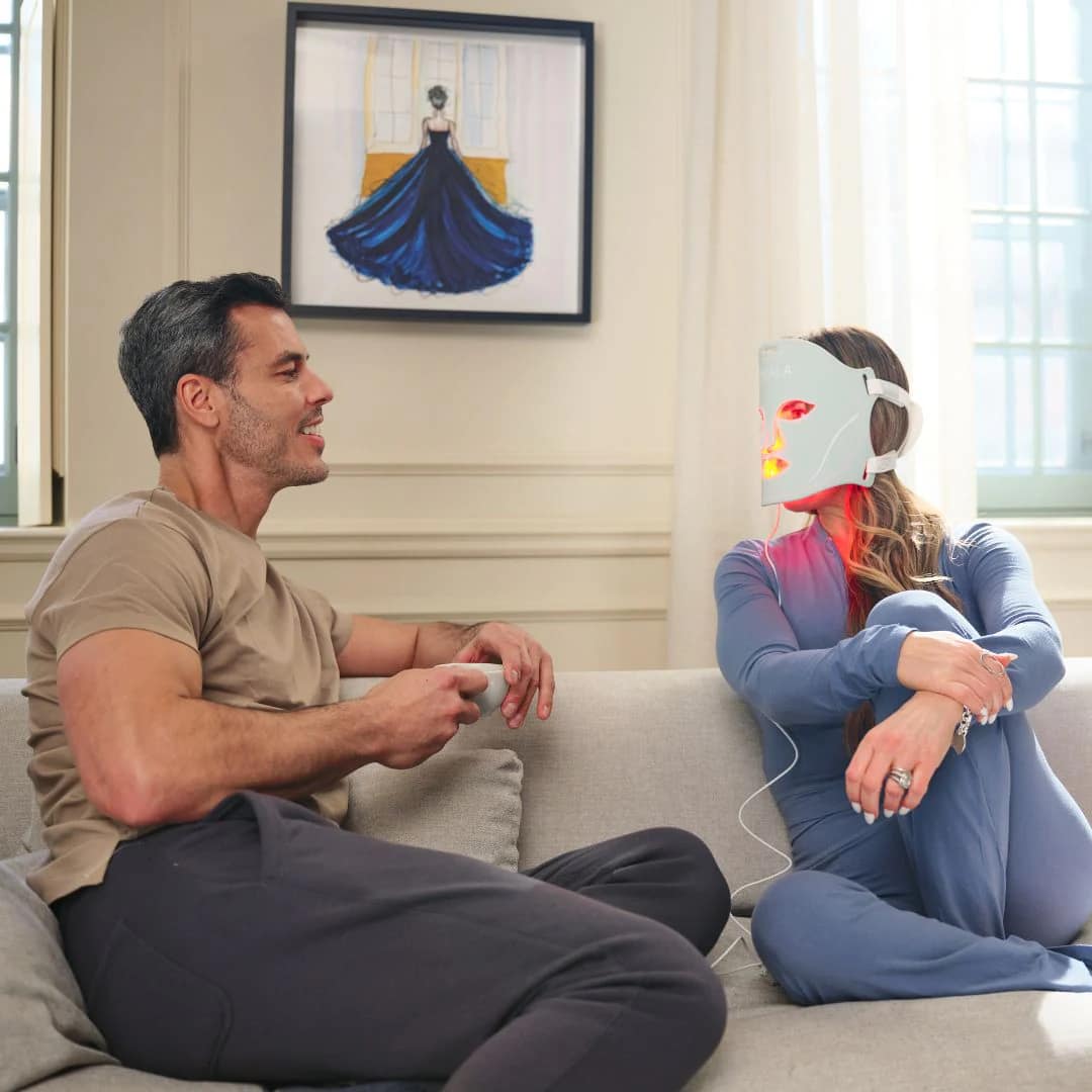 Couoke using Kala Red Light Therapy Face Mask on the sofa