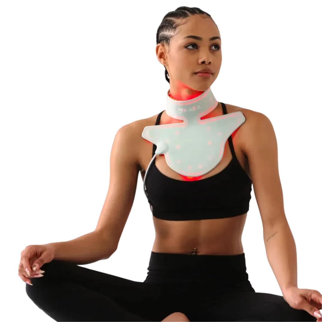 Woman relaxing on floor while using Kala Red Light Therapy Neck Piece for comfortable LED session
