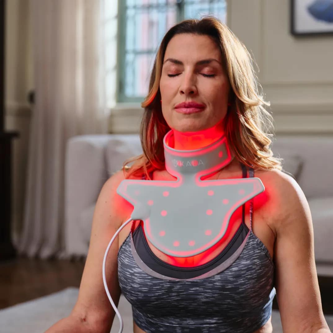 Woman using Kala Red Light Neck Rejuvenator for targeted décolletage and jawline treatment session