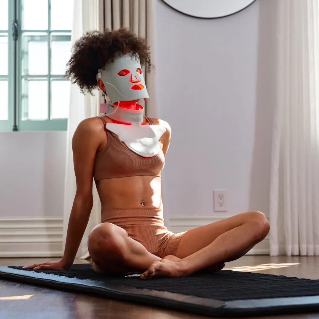 Woman practicing yoga while wearing Kala LED Neck Piece for hands-free multitasking light therapy