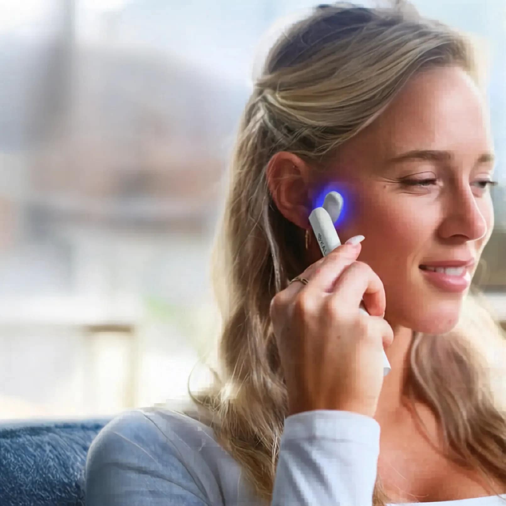 Woman using Kala Wand in blue light mode for acne treatment and targeted skin clarifying therapy