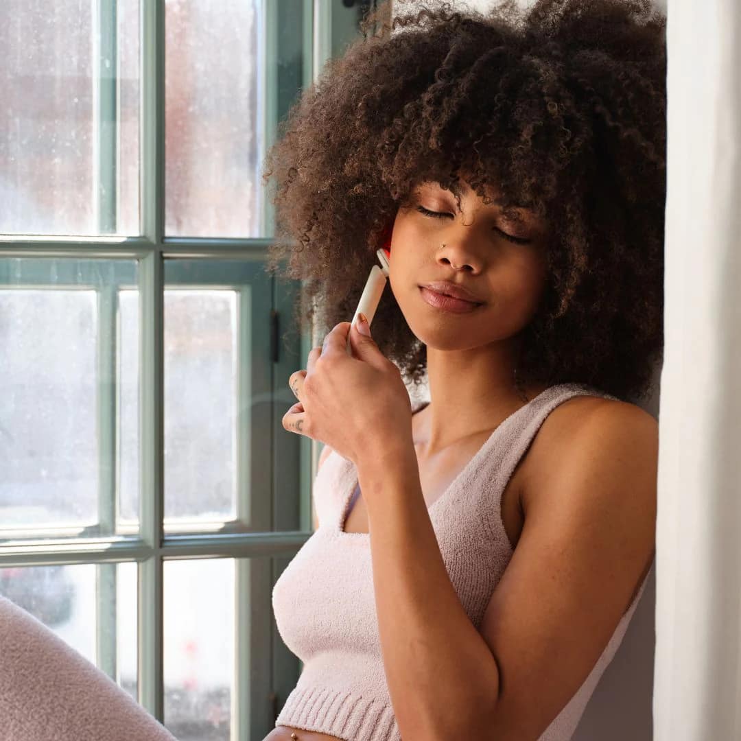 Woman using Kala Red Light Therapy Wand on face for targeted at-home LED anti-aging treatment session