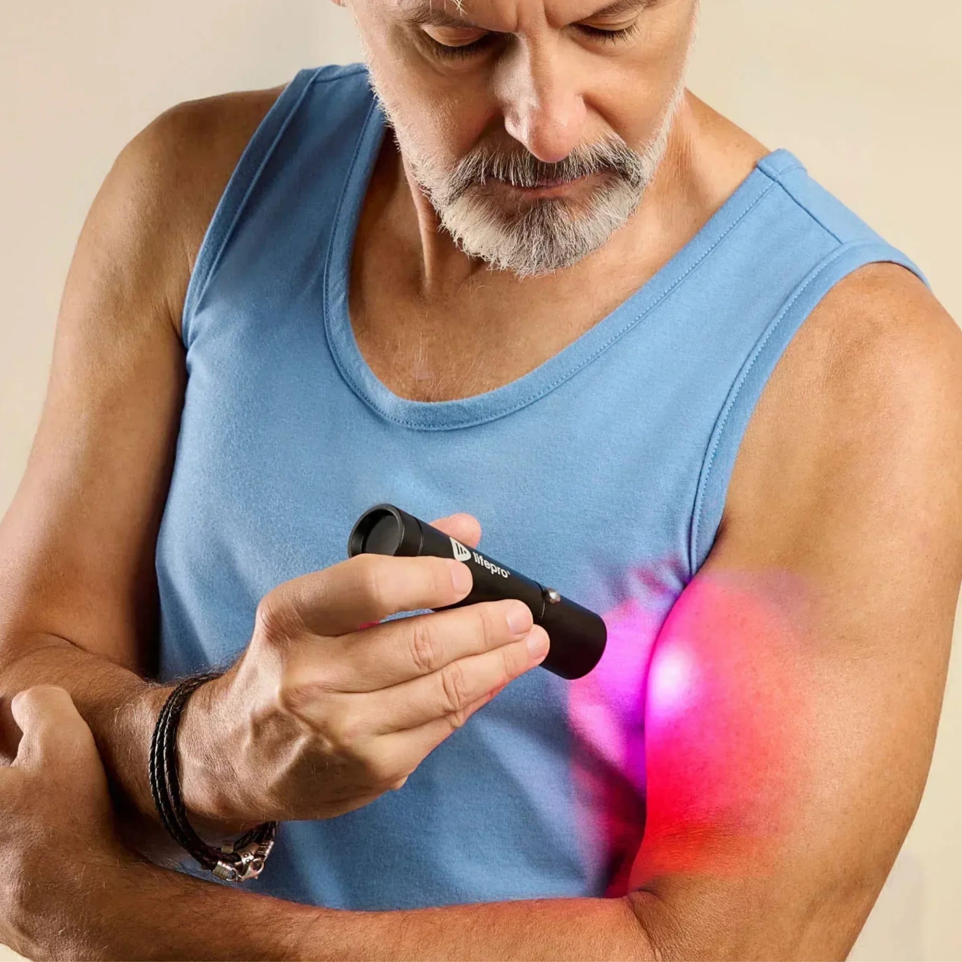 Man applying LifePro Red Light Torch to arm for targeted muscle recovery and pain relief therapy