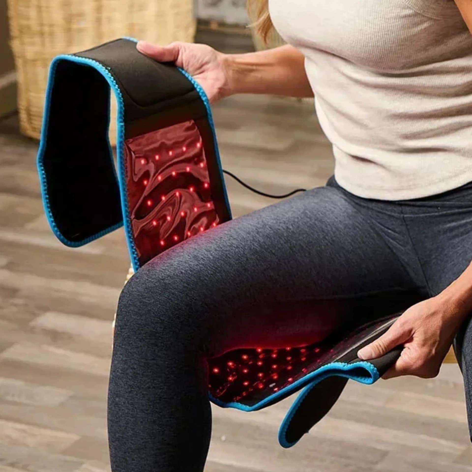 Woman wrapping LifePro Red Light Belt around thigh for targeted muscle recovery treatment