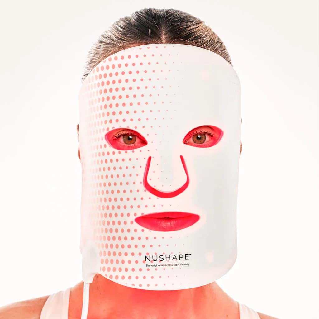 Woman enjoying a session with Nushape Red Light Therapy Face Mask
