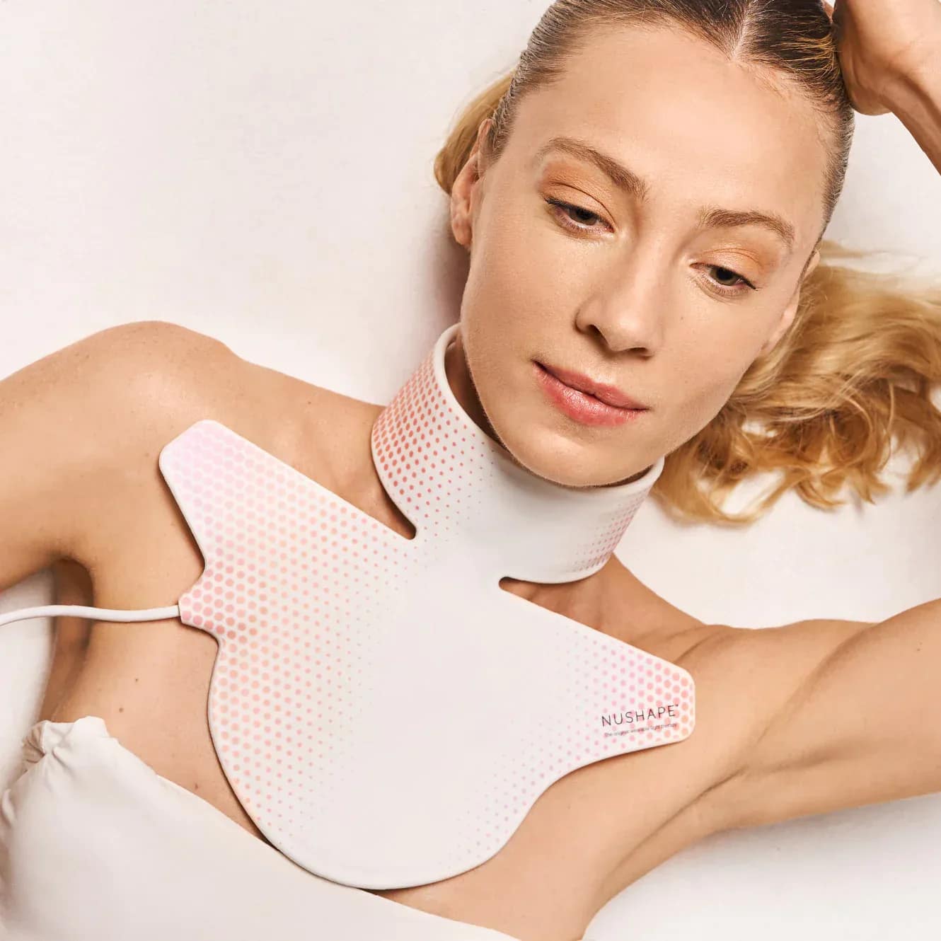 Woman relaxing while wearing Nushape Neck Device for comfortable hands-free LED treatment session