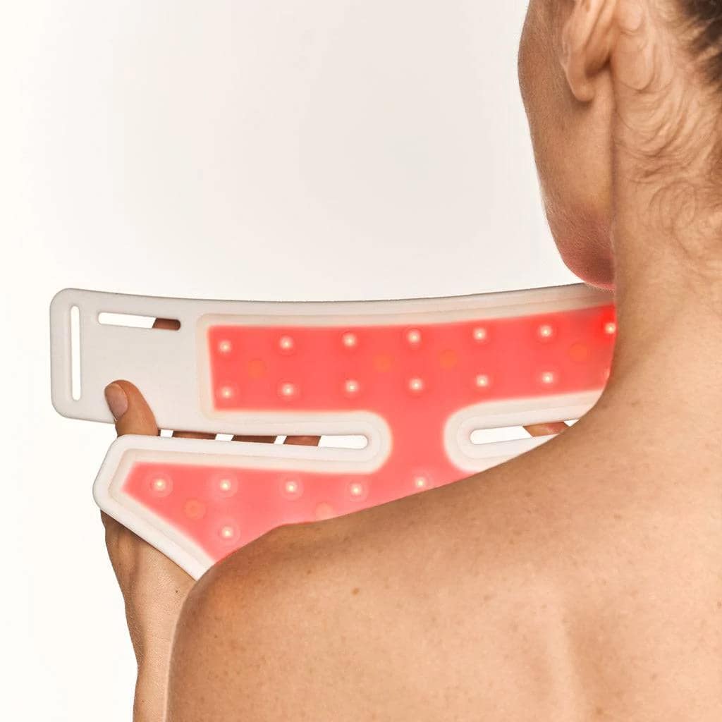 Rear view of woman holding Nushape Red Light Rejuvenator illuminated in red wavelength therapy mode