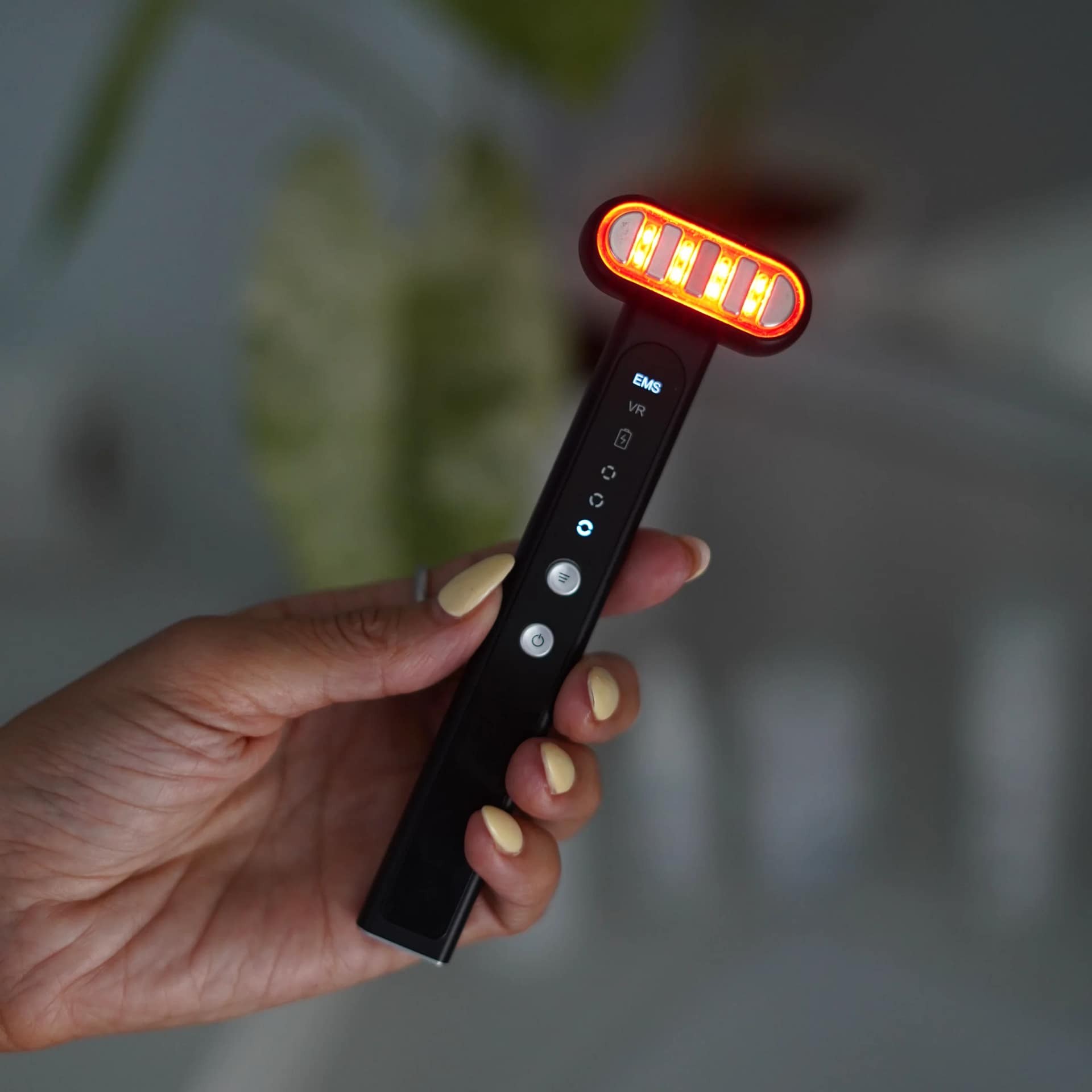 Close-up of Therasage TheraSculpt showing illuminated red LED mode and advanced rotating head design